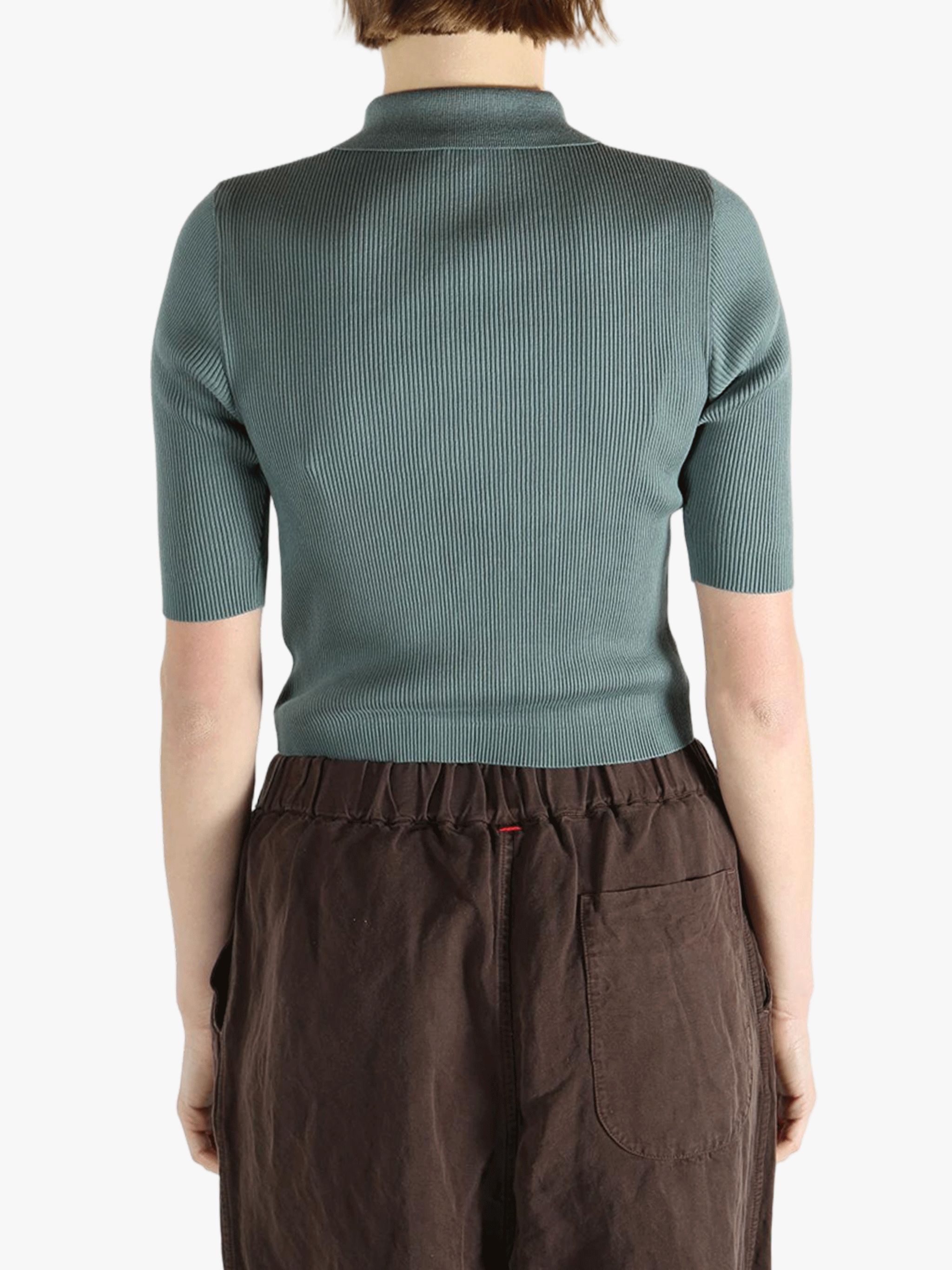 Green polo worn by a person, showing the polo's fit