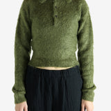 Green knitwear worn by a person, showing the knitwear's fit