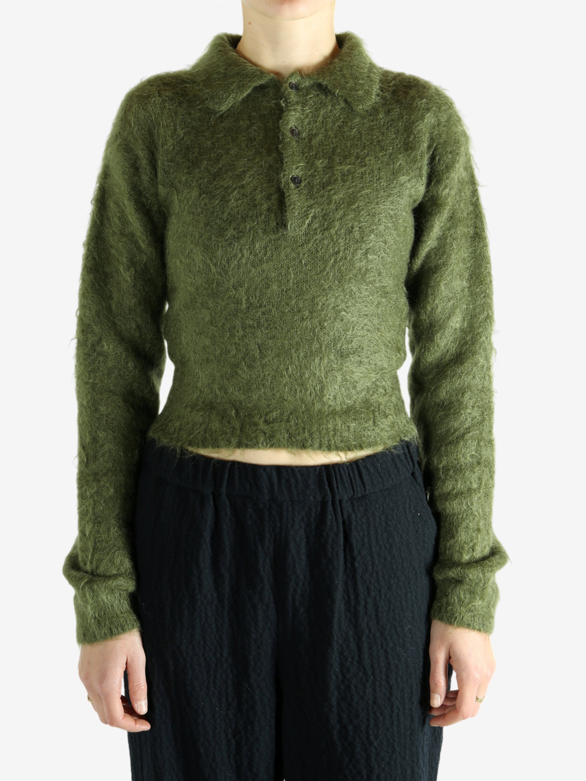 Green knitwear worn by a person, showing the knitwear's fit