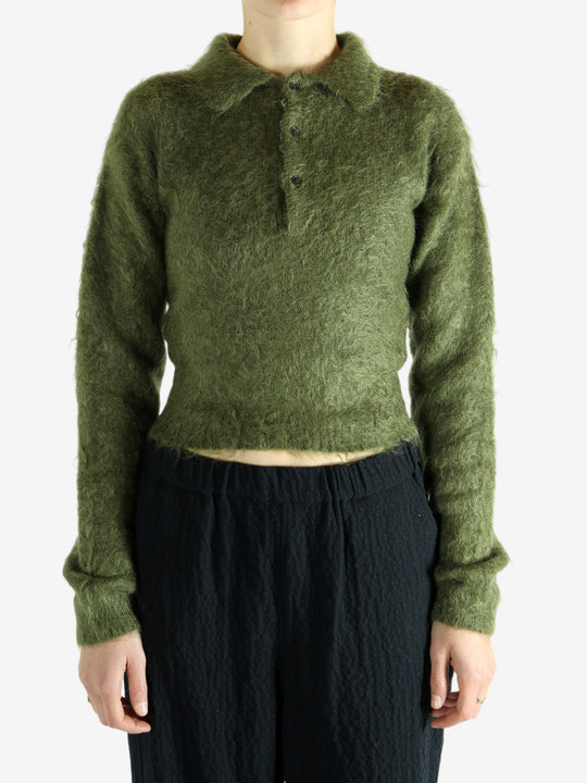 Green knitwear worn by a person, showing the knitwear's fit