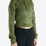 Green knitwear worn by a person, showing the knitwear's fit