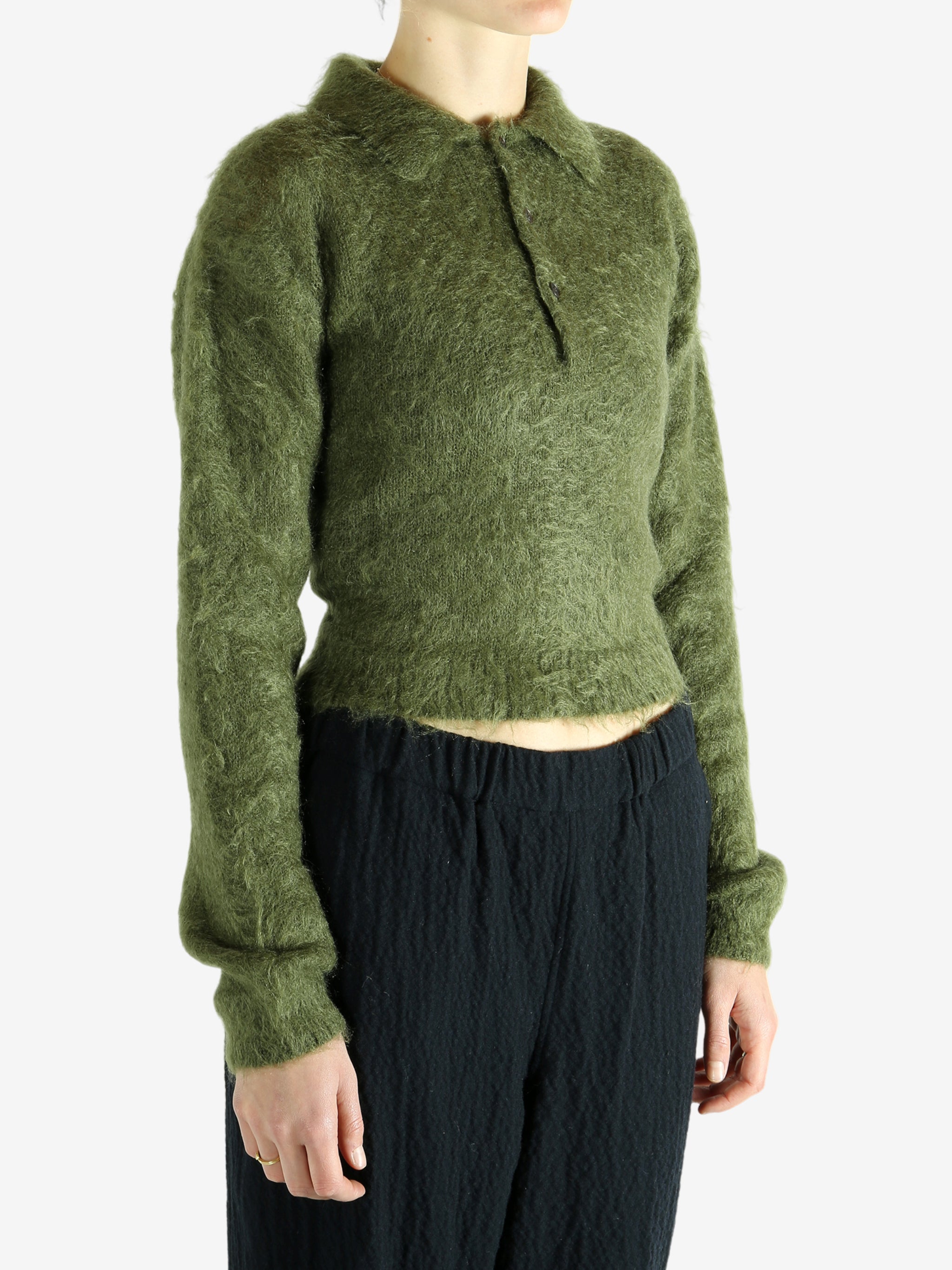 Green knitwear worn by a person, showing the knitwear's fit