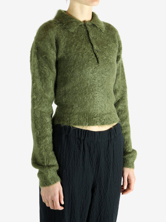 Green knitwear worn by a person, showing the knitwear's fit