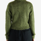 Green knitwear worn by a person, showing the knitwear's fit