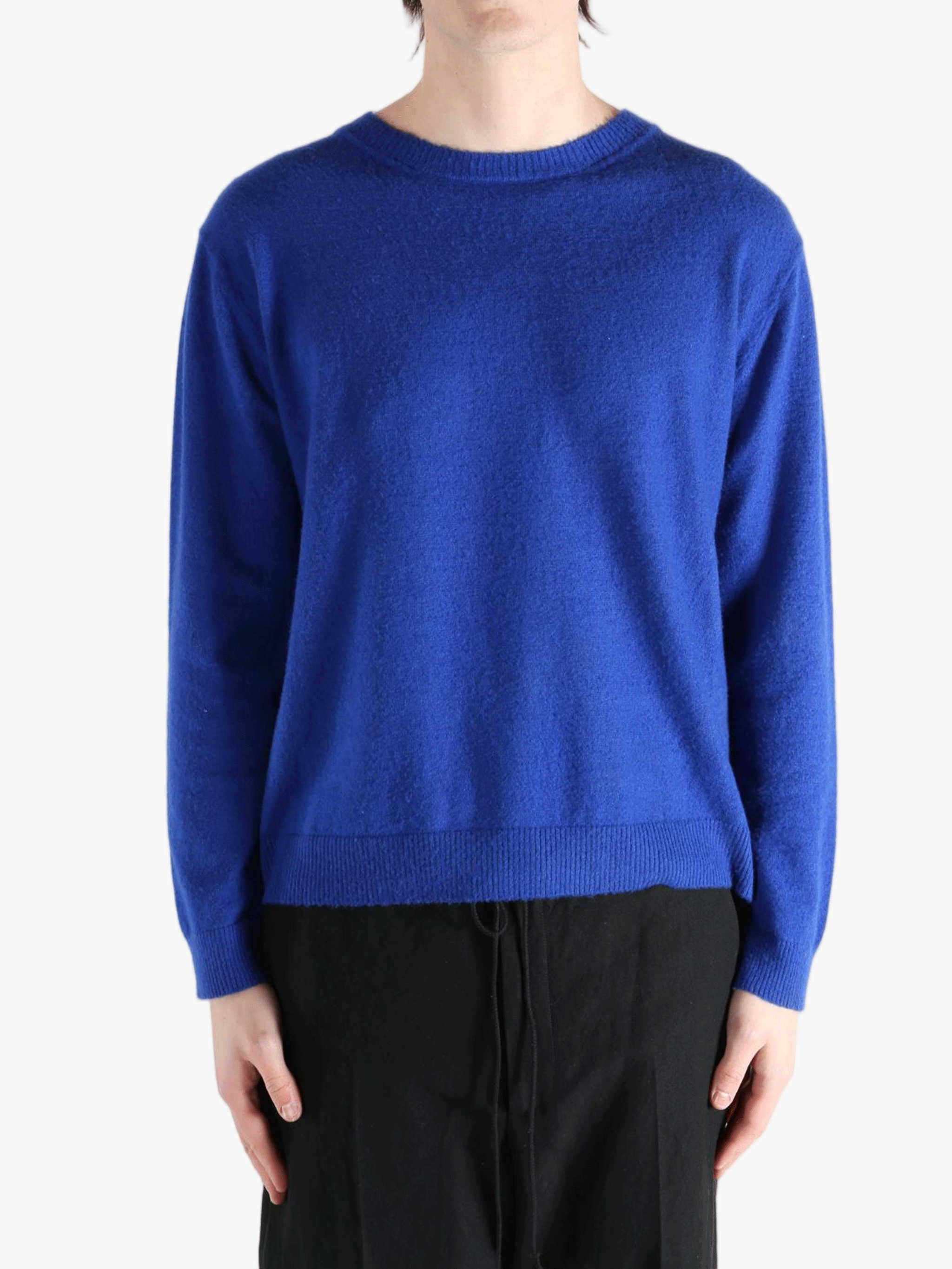 Blue knitwear worn by a person, showing the knitwear fit