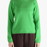 Green knitwear worn by a person, showing the knitwear's fit