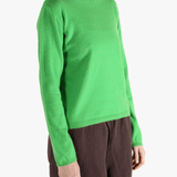 Green knitwear worn by a person, showing the knitwear's fit