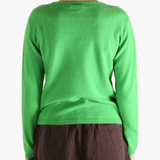 Green knitwear worn by a person, showing the knitwear's fit