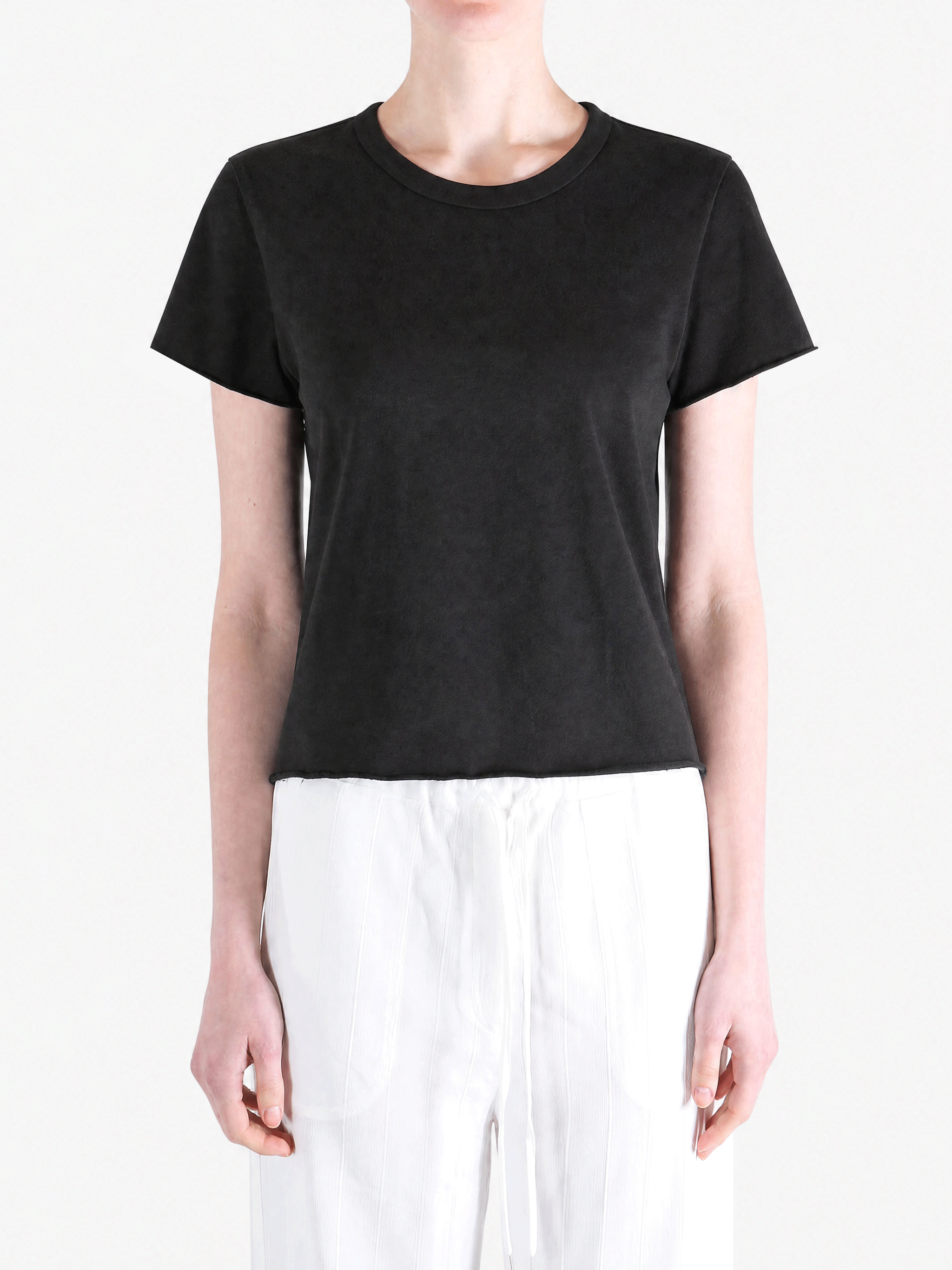Black tee worn by a person, showing the tee fit