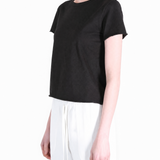 Black tee worn by a person, showing the tee fit