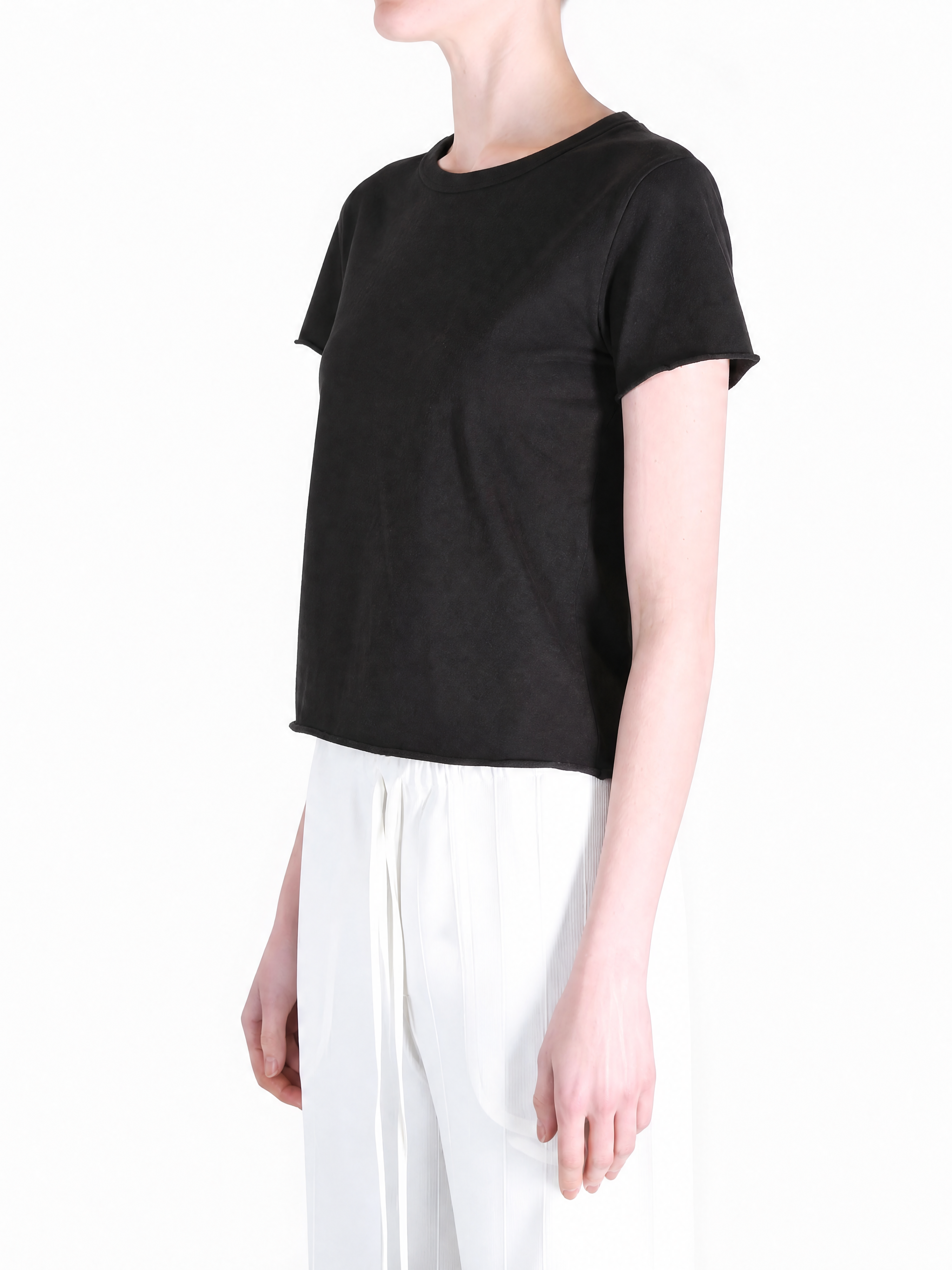 Black tee worn by a person, showing the tee fit