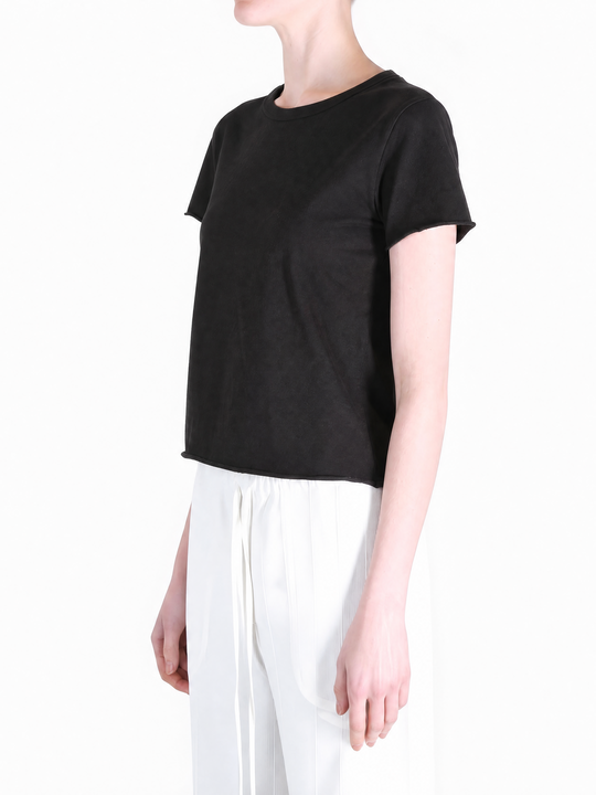 Black tee worn by a person, showing the tee fit