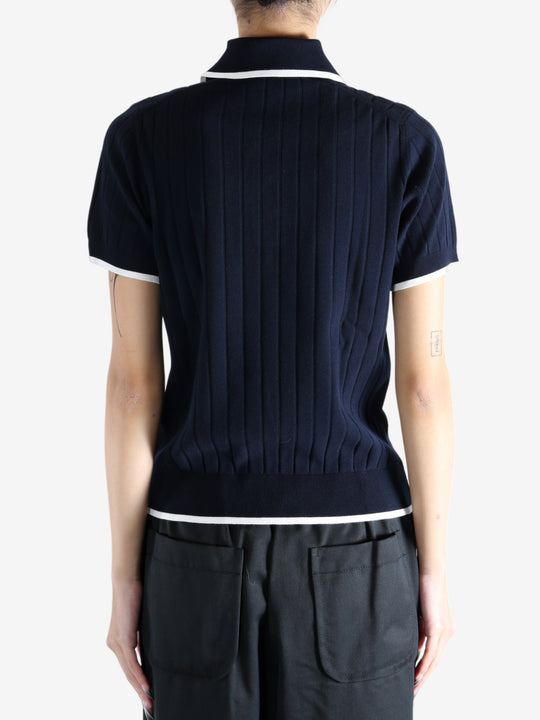 Navy knitwear worn by a person, showing the knitwear's fit