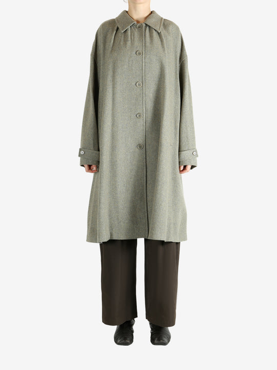 Grey coat worn by a person, showing the coat fit