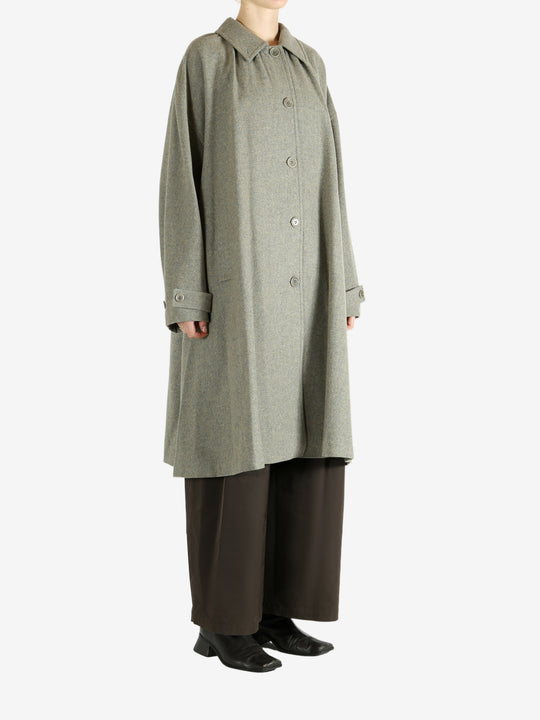 Grey coat worn by a person, showing the coat fit