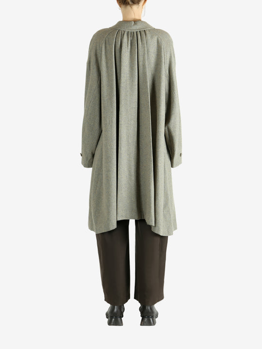 Grey coat worn by a person, showing the coat fit