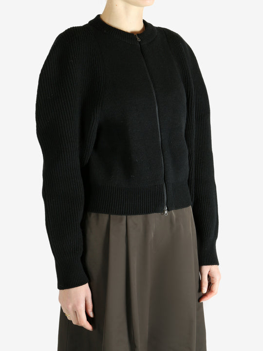 Black cardigan worn by a person, showing the cardigan fit