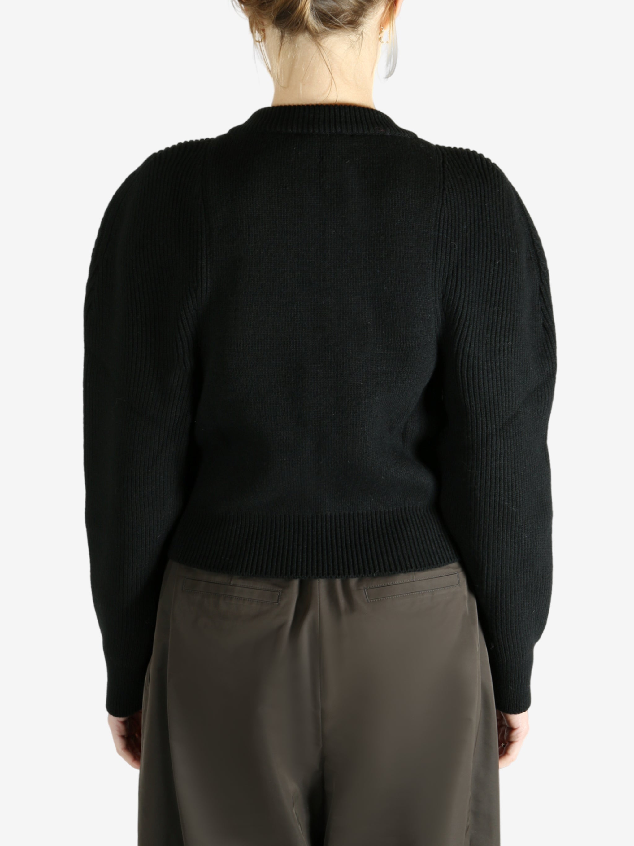 Black cardigan worn by a person, showing the cardigan fit