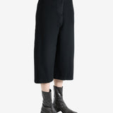 Black pants worn by a person, showing the pants fit