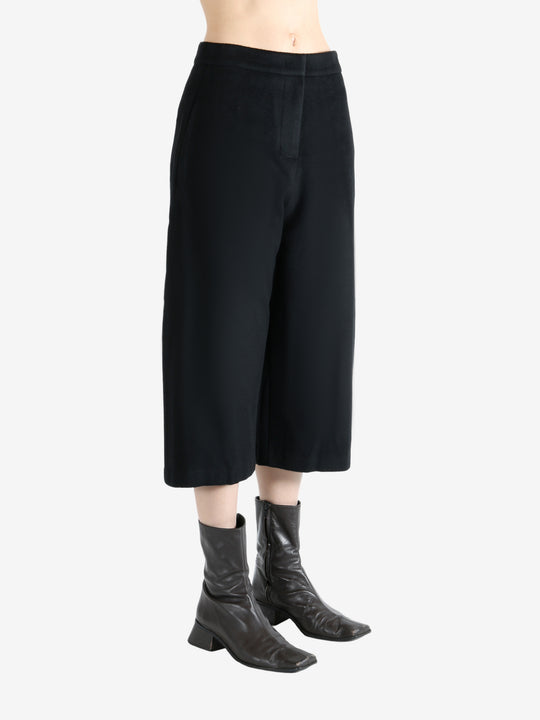 Black pants worn by a person, showing the pants fit