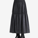 Black skirt worn by a person, side view
