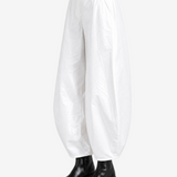 White pants worn by a person, showing the pants' fit