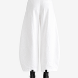 White pants worn by a person, showing the pants' fit