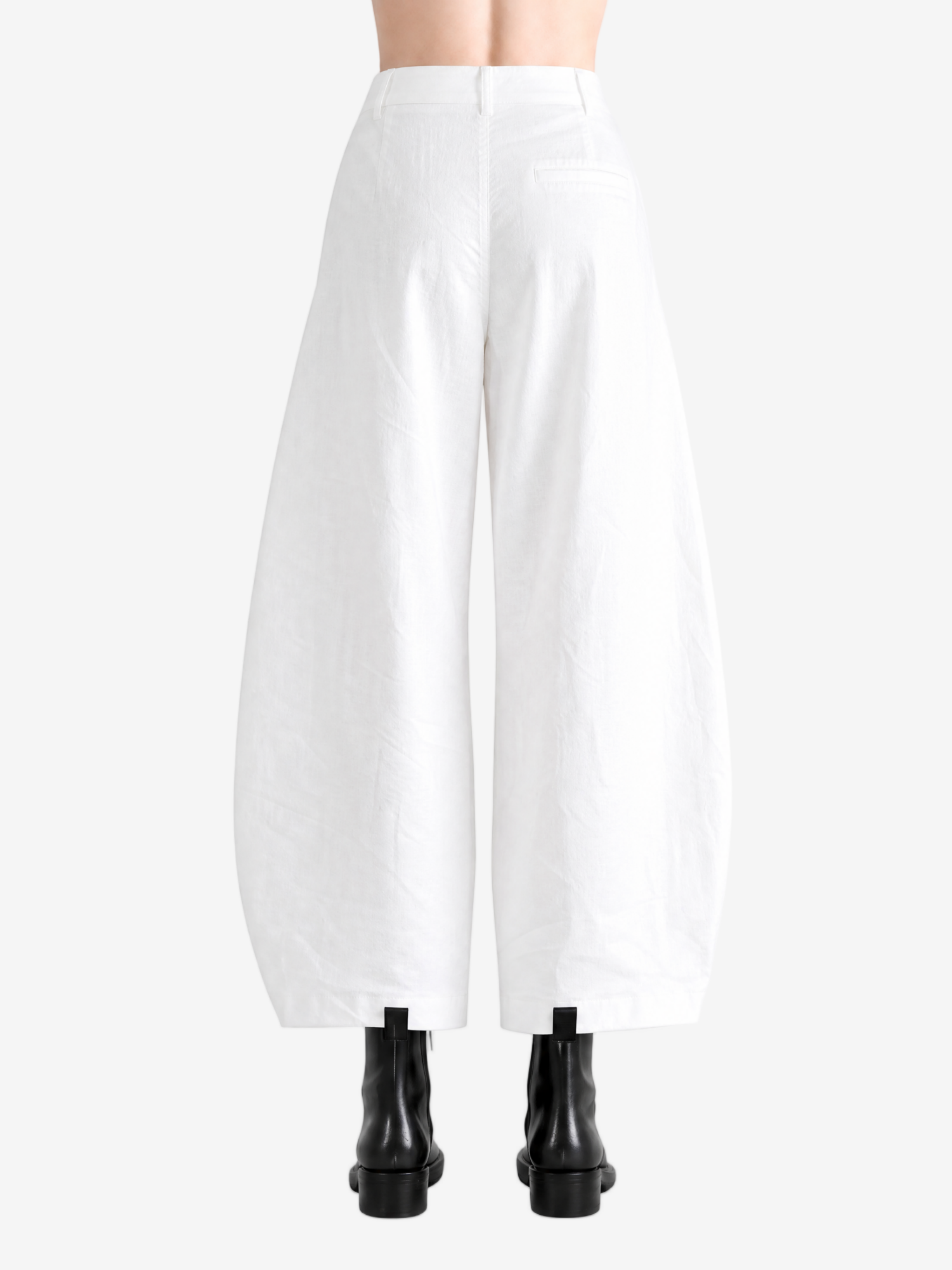 White pants worn by a person, showing the pants' fit