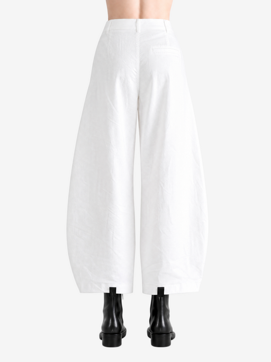 White pants worn by a person, showing the pants' fit