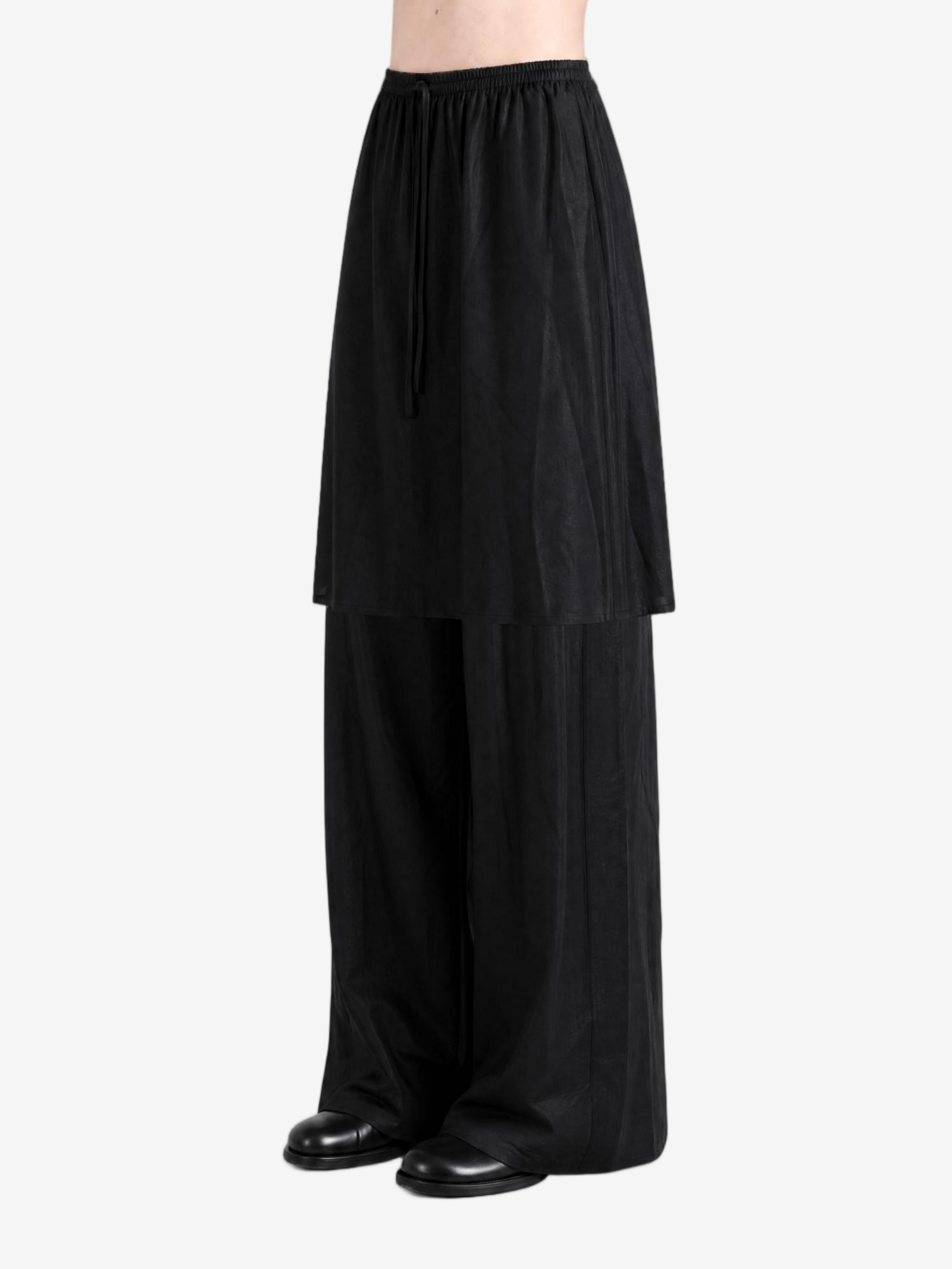 Black pants worn by a person, showing the pants fit