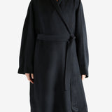 Black coat worn by a person, showing the coat fit