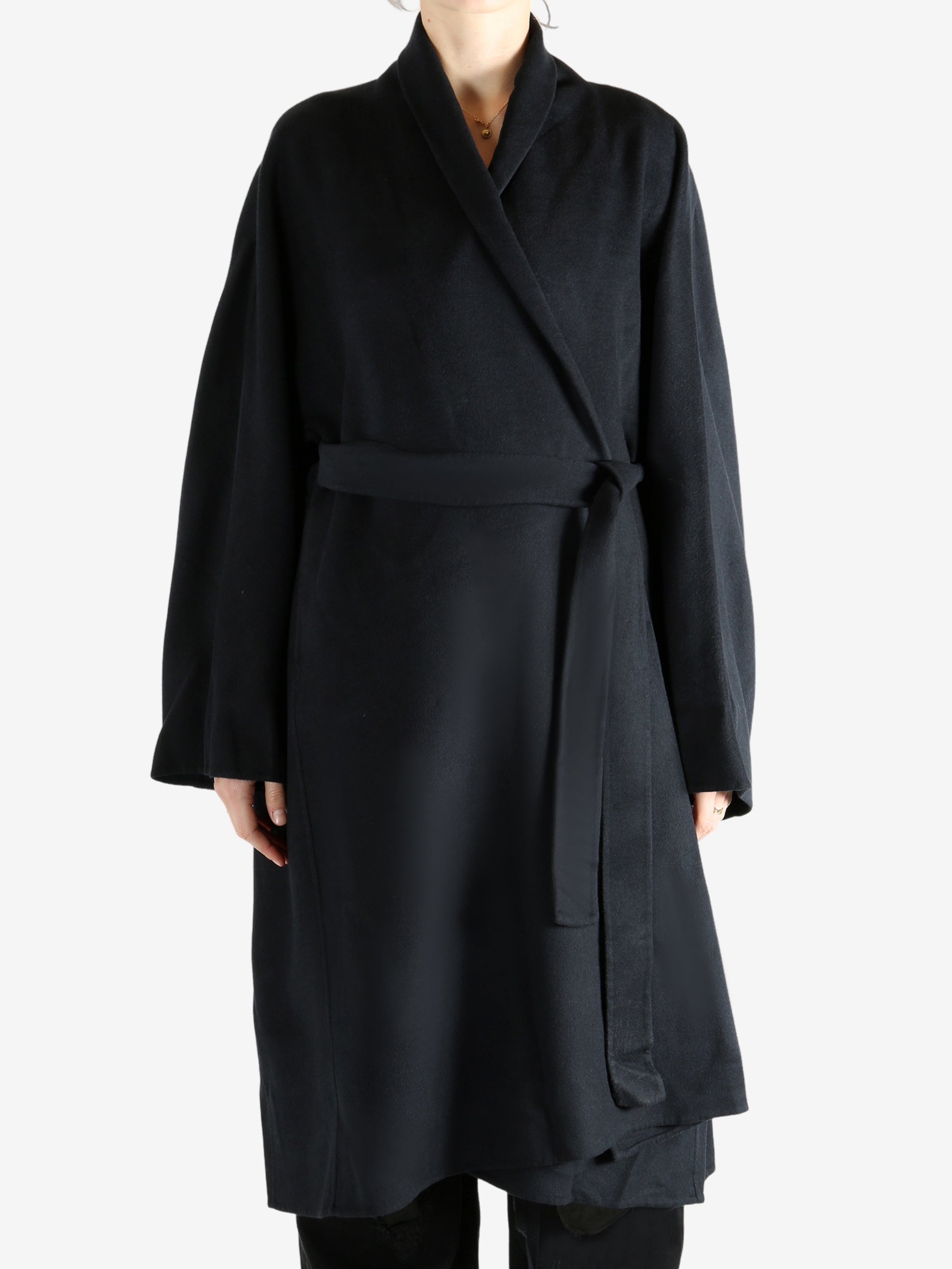 Black coat worn by a person, showing the coat fit