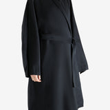 Black coat worn by a person, showing the coat fit