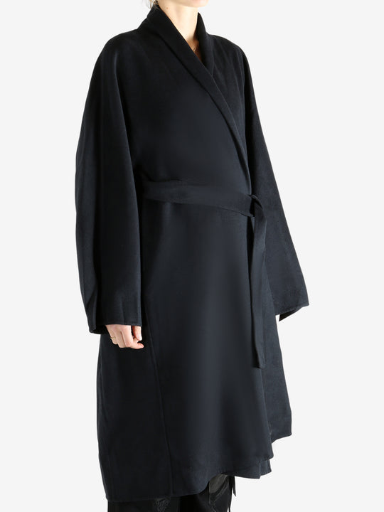 Black coat worn by a person, showing the coat fit