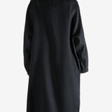Black coat worn by a person, showing the coat fit