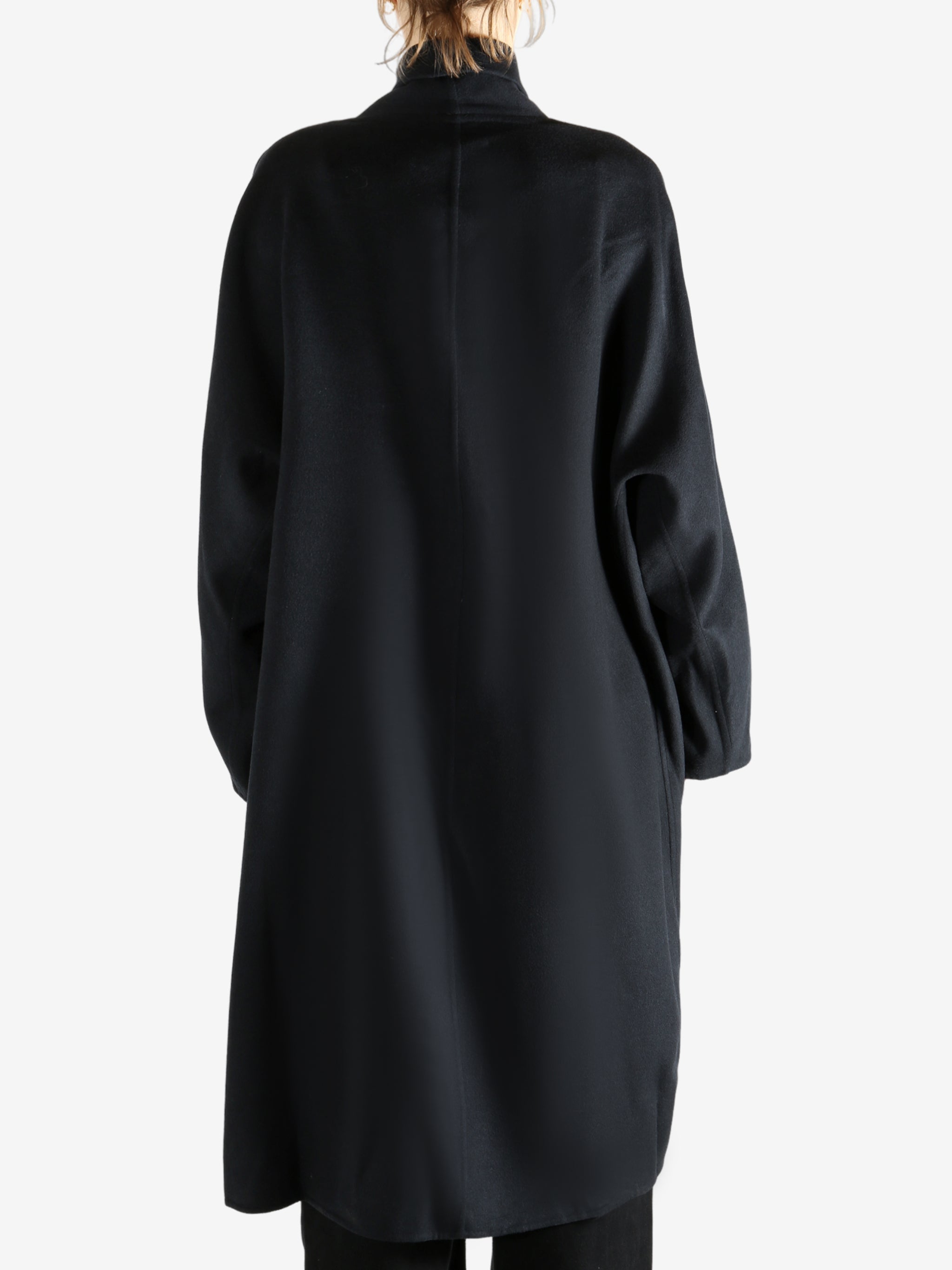 Black coat worn by a person, showing the coat fit