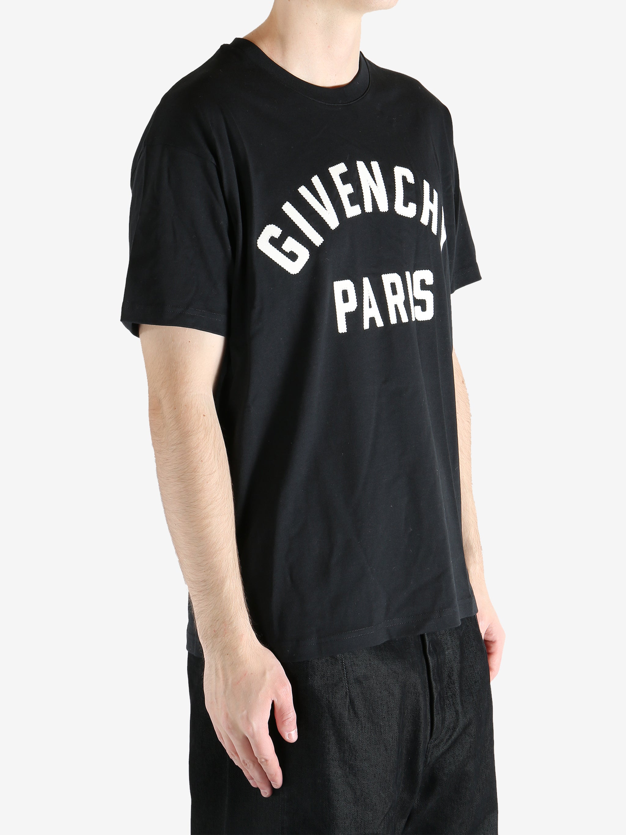 Black t-shirts worn by a person, showing the t-shirts fit