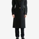 Black coat worn by a person, showing the coat fit