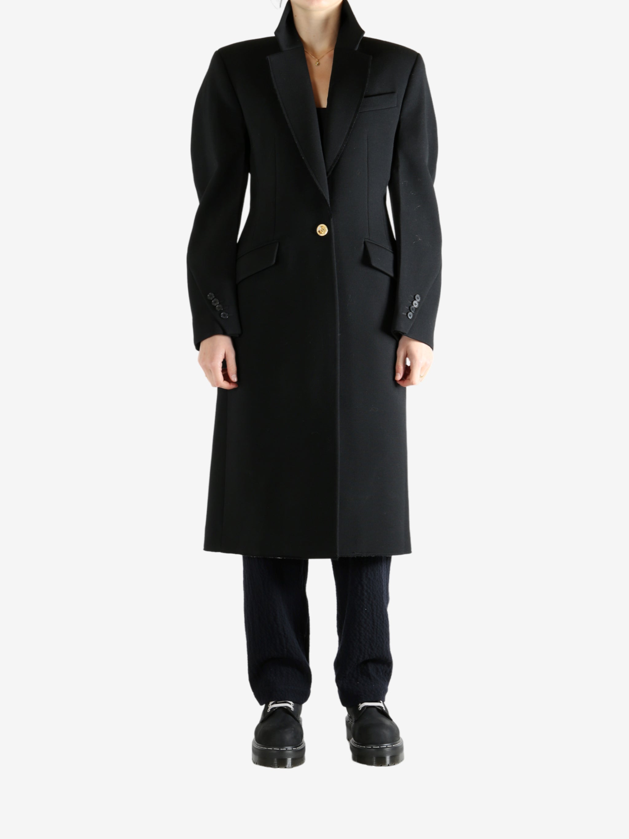 Black coat worn by a person, showing the coat fit