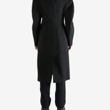 Black coat worn by a person, showing the coat fit