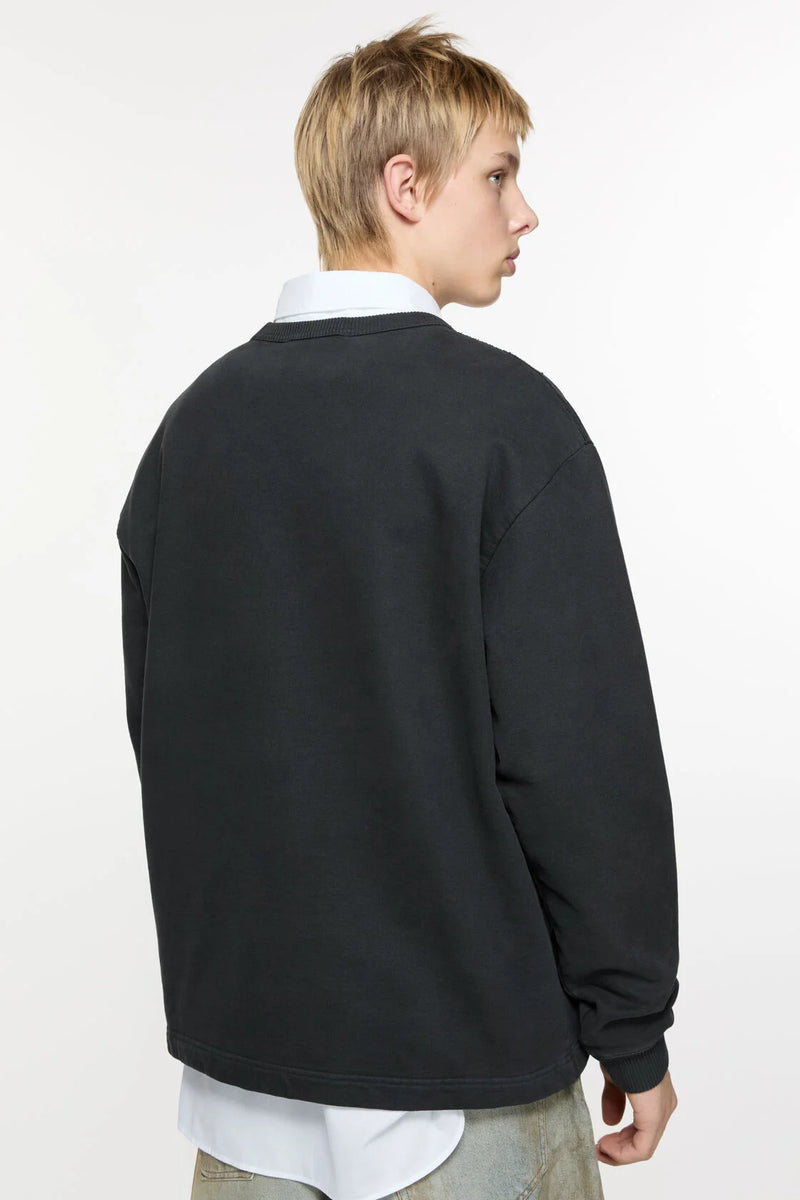 Black sweater worn by a person, showing the sweater's fit