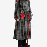 Black coat worn by a person, showing the coat's fit