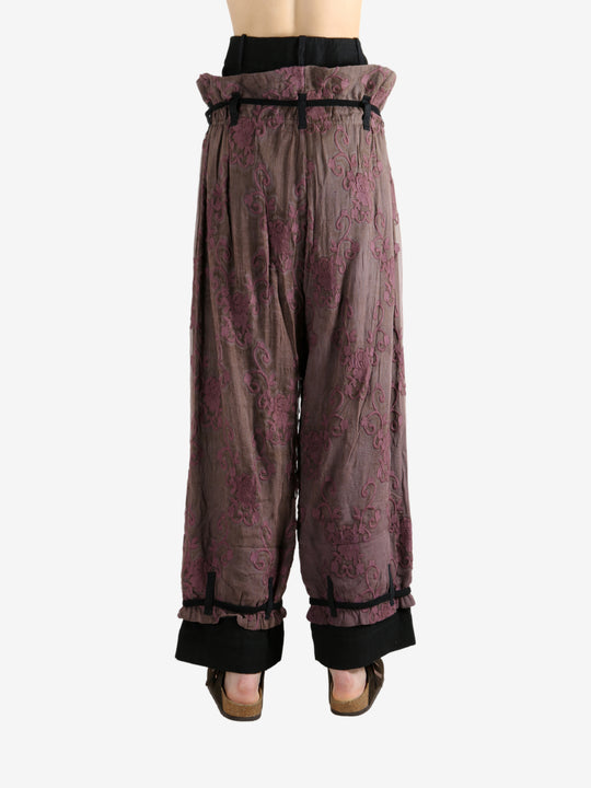 Purple pants worn by a person, showing the pants's fit