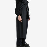 Black coat worn by a person, showing the coat fit