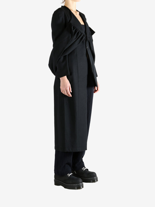 Black coat worn by a person, showing the coat fit