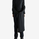 Black coat worn by a person, showing the coat fit