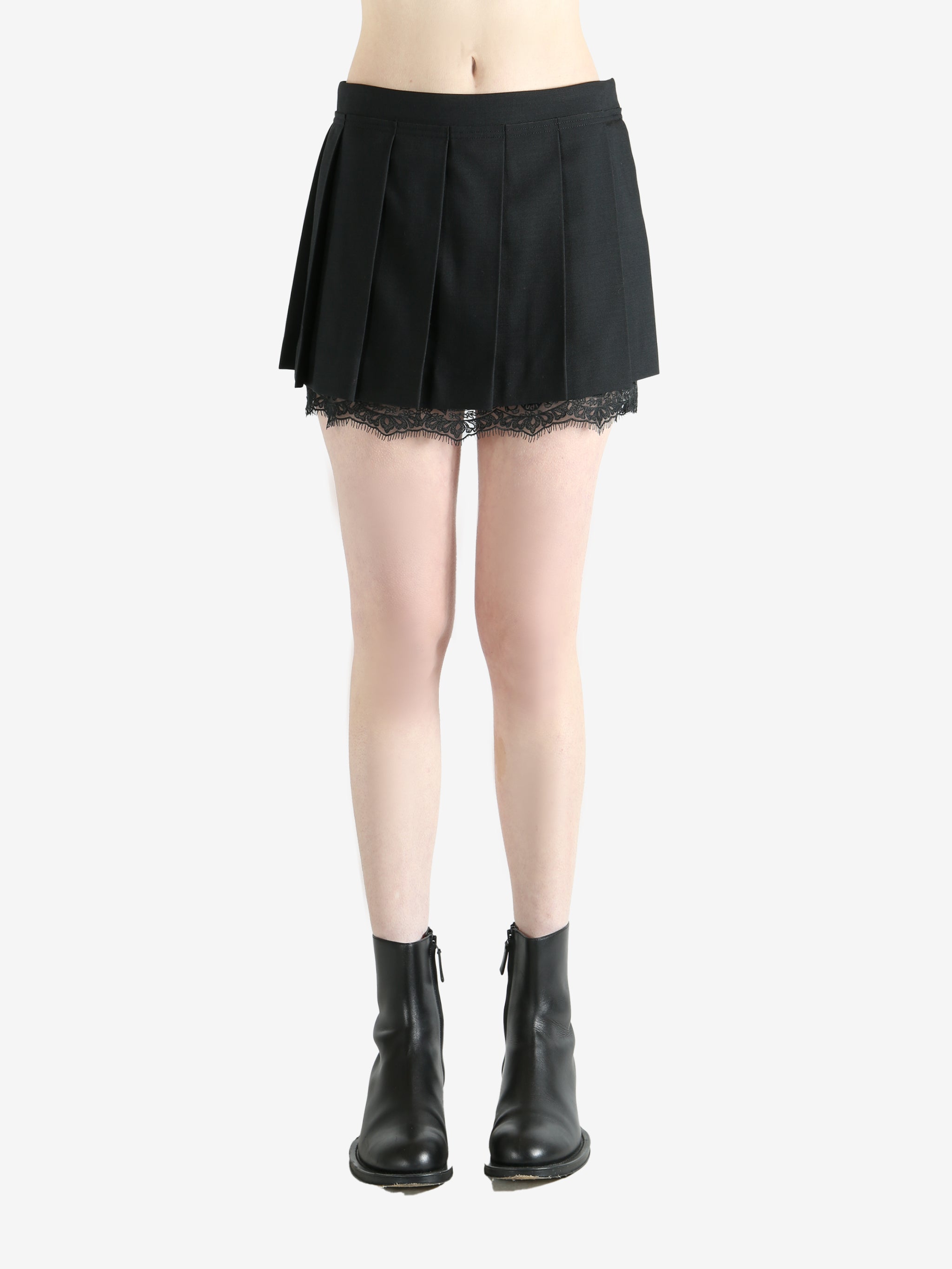 black pleated skirt worn by a person, showing the skirt fit