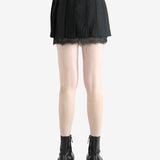 black pleated skirt worn by a person, showing the skirt fit