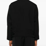 Black coat  worn by a person, showing the coat's fit