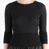 Black knitwear worn by a person,showing the knitwear fit